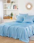Bamboo Flat Sheets in light blue on a bed in a bright minimalist bedroom