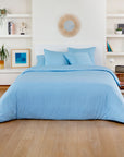 Soft blue bamboo duvet cover with matching blue pillows in a bright white bedroom