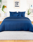 Deep blue bamboo duvet cover with lighter blue pillows on a white bed in a calm room