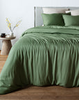 Olive Green bambaw cozy bamboo bedspread on a bed in a bedroom with a side table and decor.