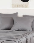 Gray bamboo pillowcases two-pack on a bed with light neutral bedding.