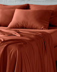bambaw cozy terracotta bed sheets and pillows on a bed with a neutral background