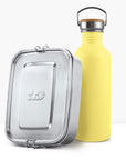 Yellow non insulated bottle with a wooden lid handle beside a silver lunch tin.