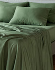 bambaw cozy bamboo bed sheets close up on a bed with flat sheets and pillows in olive green colour