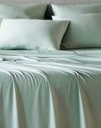 bambaw cozy bamboo bed sheets close up on a bed with flat sheets and pillows in sea glass colour