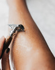 Person shaves forearm with a bamboo handled razor.