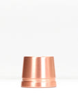 Copper safety razor stand on white surface with packaging box in background