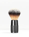 Shaving brush with a knurled black handle and dense light to dark bristles against a white background