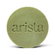 Close-up of pale green round arista shampoo bar with embossed lettering