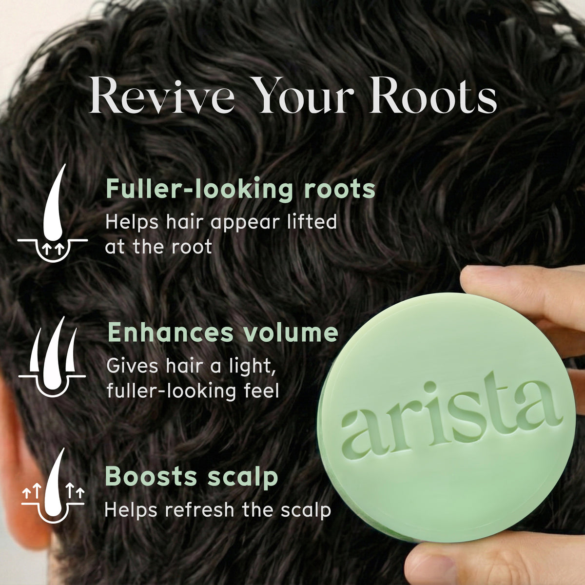 Close up of dark hair with a pale green circular shampoo bar held at the bottom right