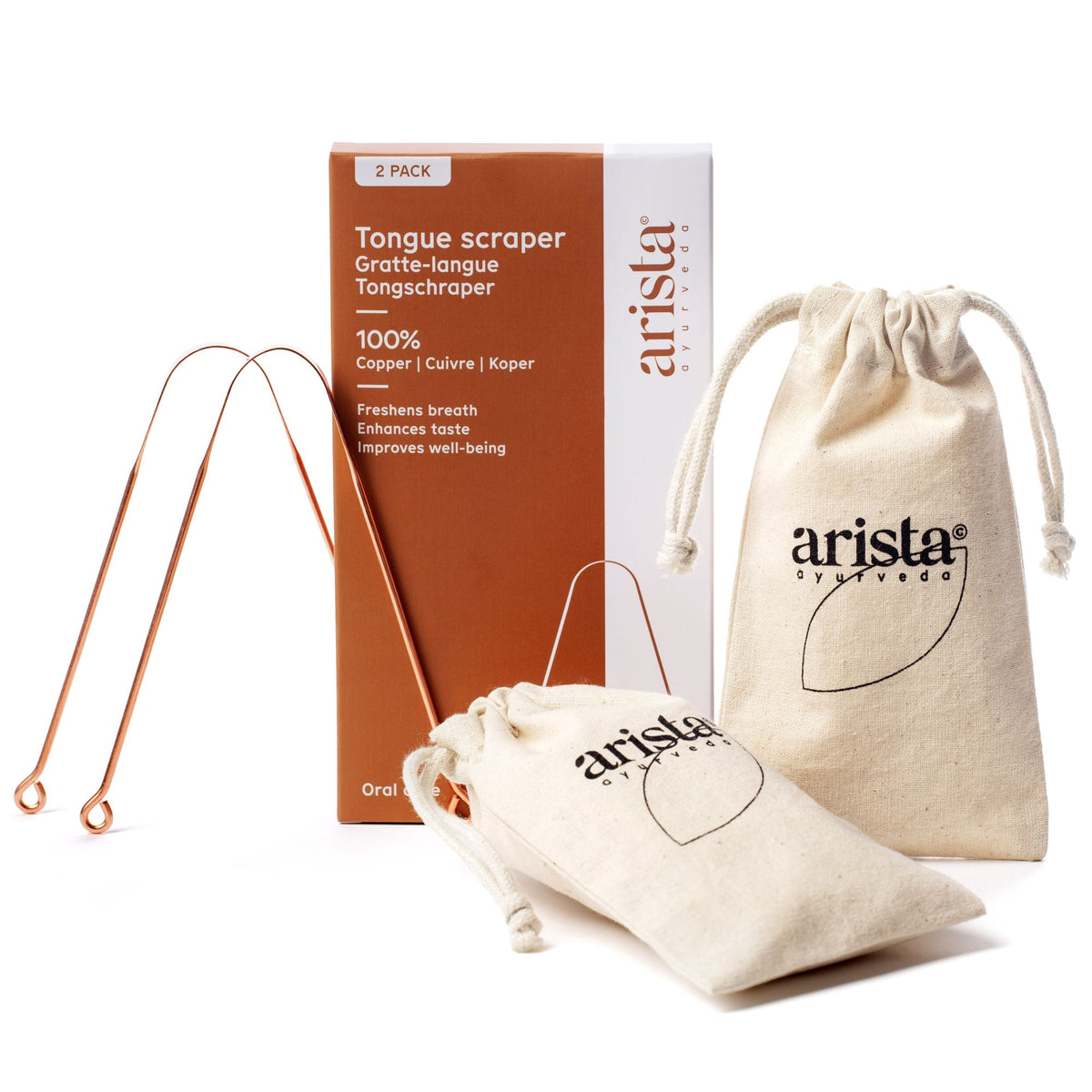 Copper tongue scrapers beside beige drawstring pouches and a brown packaging box in a product shot