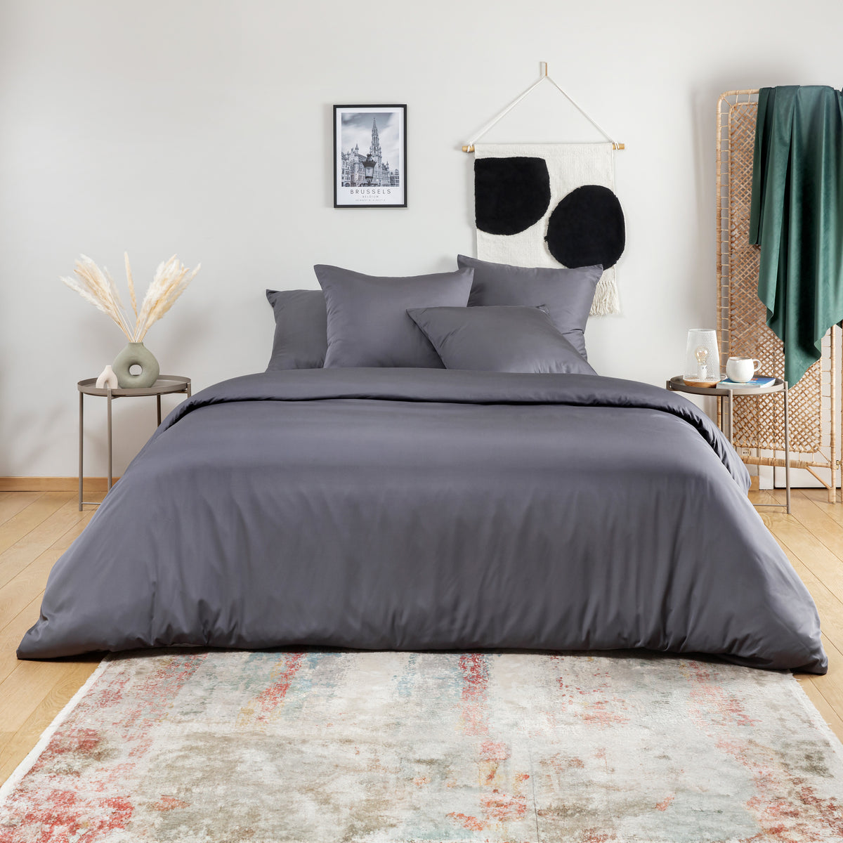 Bed dressed in a dark slate grey bamboo duvet cover with matching pillows in a minimalist bedroom.