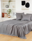 Bamboo Flat Sheets in soft grey cover a bed with matching pillowcases in a serene room.