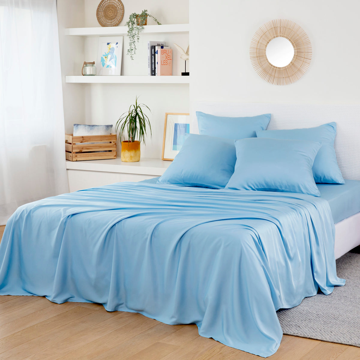 Bamboo Flat Sheets in light blue on a bed in a bright minimalist bedroom