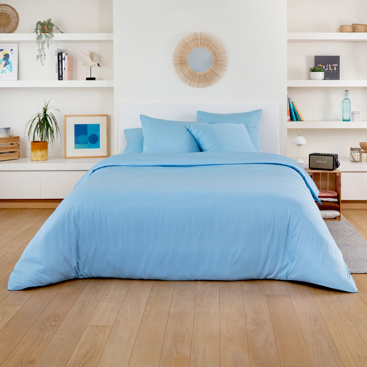 Soft blue bamboo duvet cover with matching blue pillows in a bright white bedroom