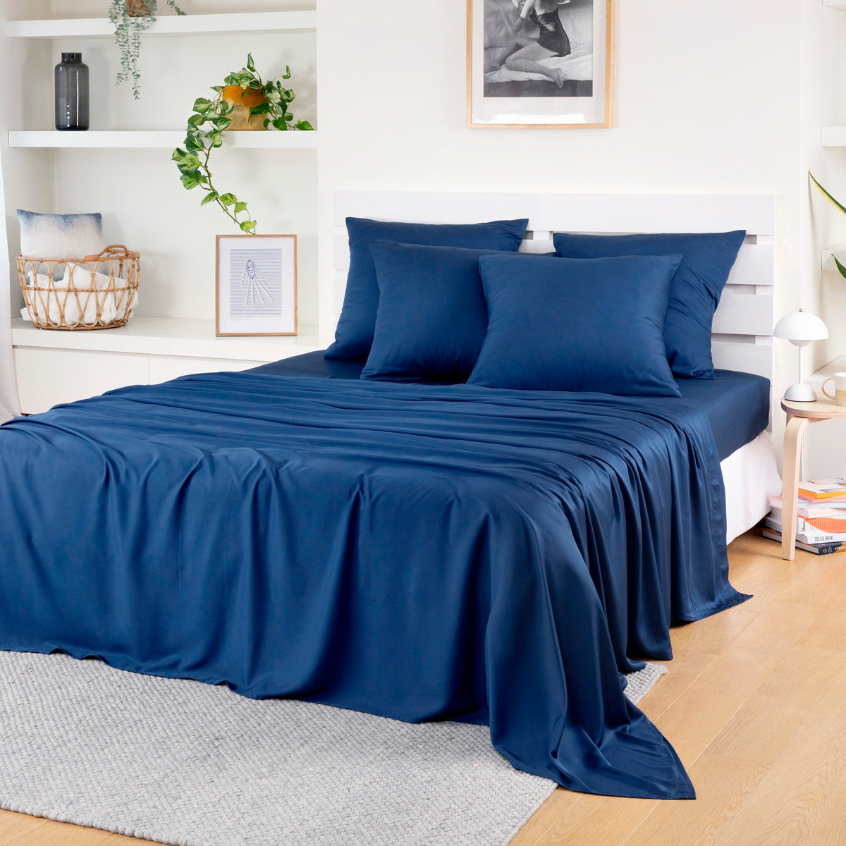 Navy blue Bamboo Flat Sheets on a bed with a white headboard in a bright room