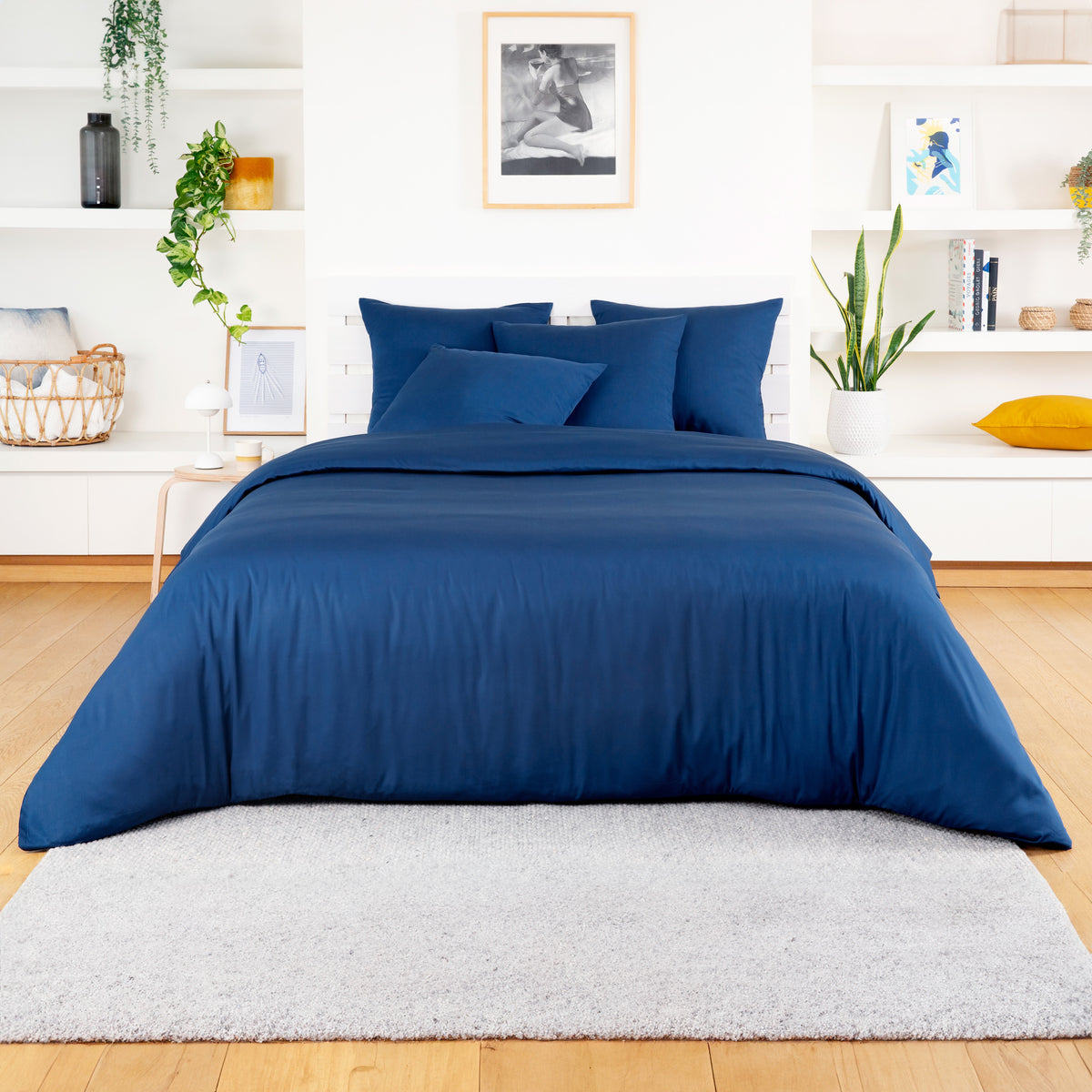 Deep blue bamboo duvet cover with lighter blue pillows on a white bed in a calm room