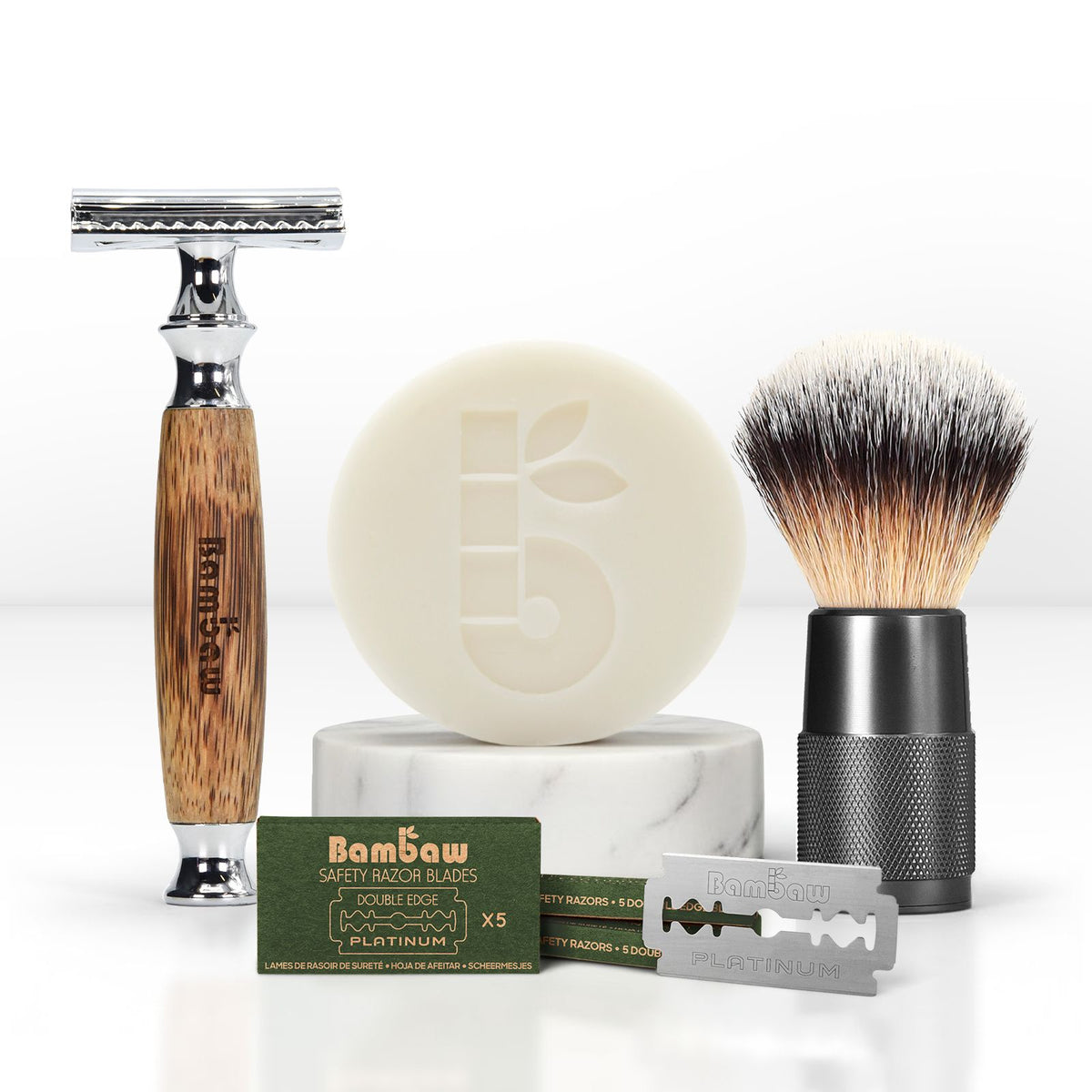 Bamboo shaving kit includes wooden razor, soap, brush and blades arranged for product shot.