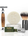 Bamboo shaving kit includes wooden razor, soap, brush and blades arranged for product shot.