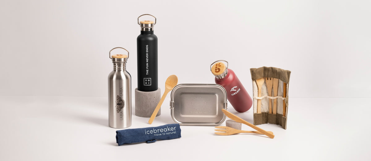 Set of reusable kitchen items including water bottles, stainless steel containers, and bamboo utensils on a light background showing customisable items of Bambaw wholesale