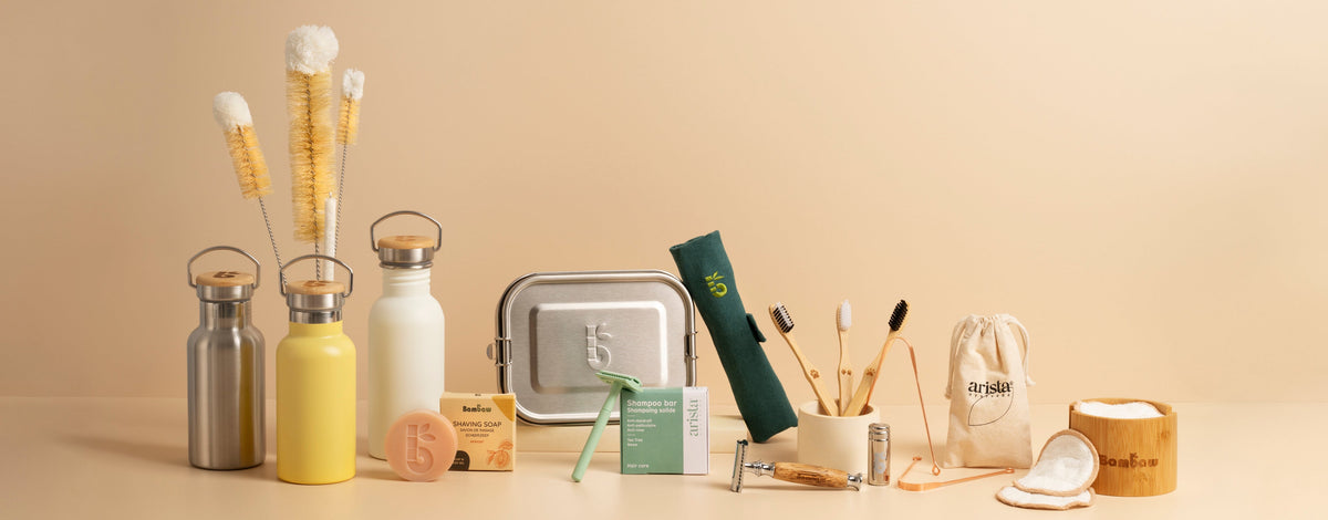 Collection of reusable products including bottles, containers, and cleaning tools on a beige background