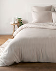 Sand Beige bamboo bedding set on a bed in a bedroom with wooden flooring and a small table