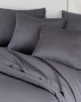 Medium gray bamboo pillowcases pack of 2 on a bed with a pale wall background