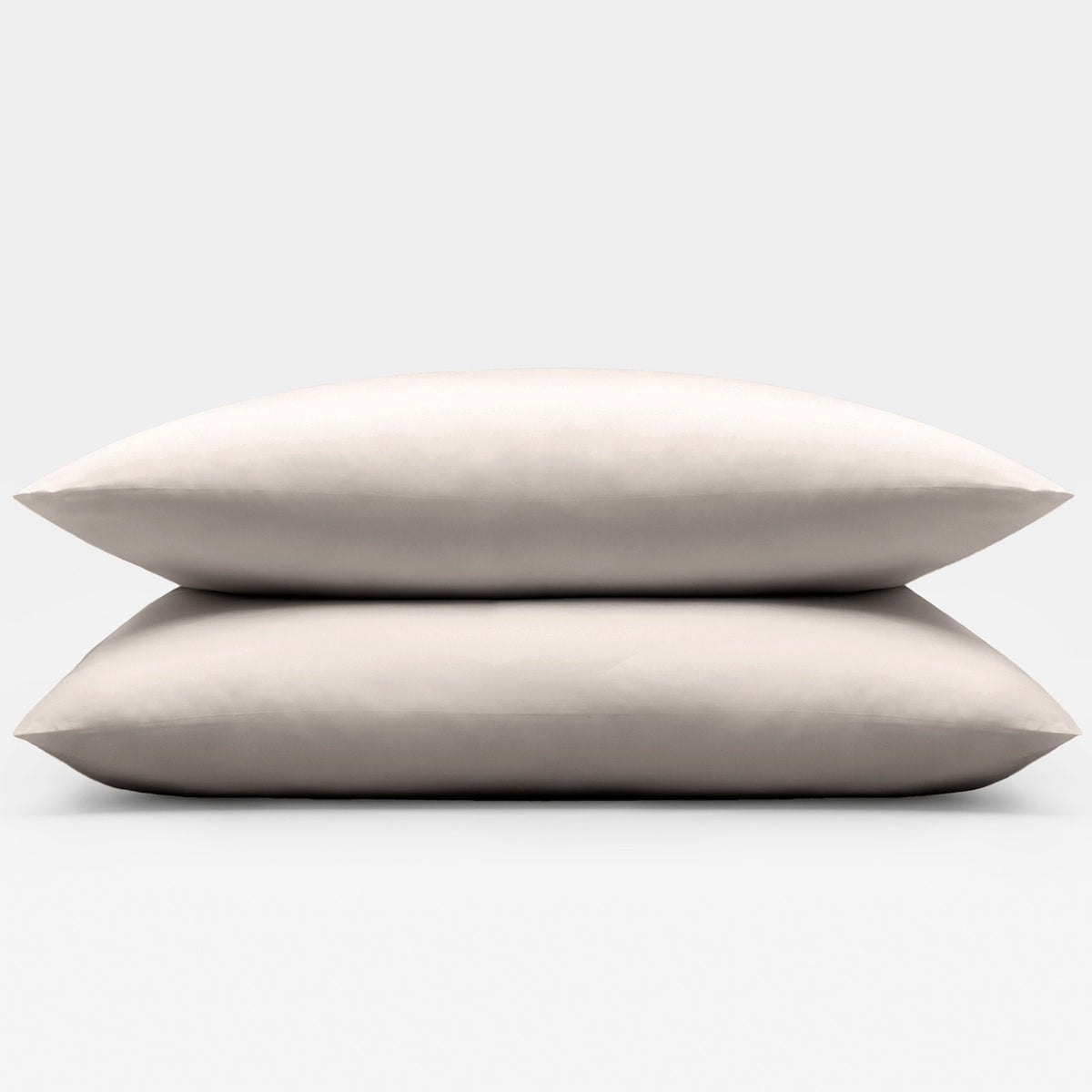Two beige sand pillows stacked on a light gray background