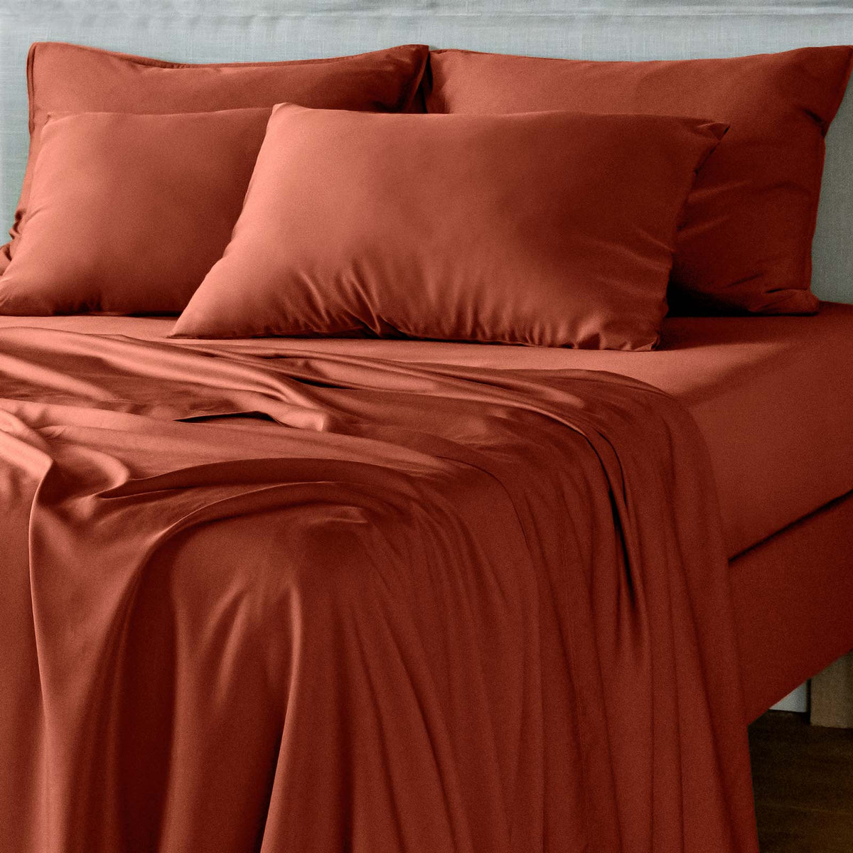bambaw cozy terracotta bed sheets and pillows on a bed with a neutral background