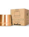 Copper safety razor stand beside a Bambaw cardboard box with bamboo graphics