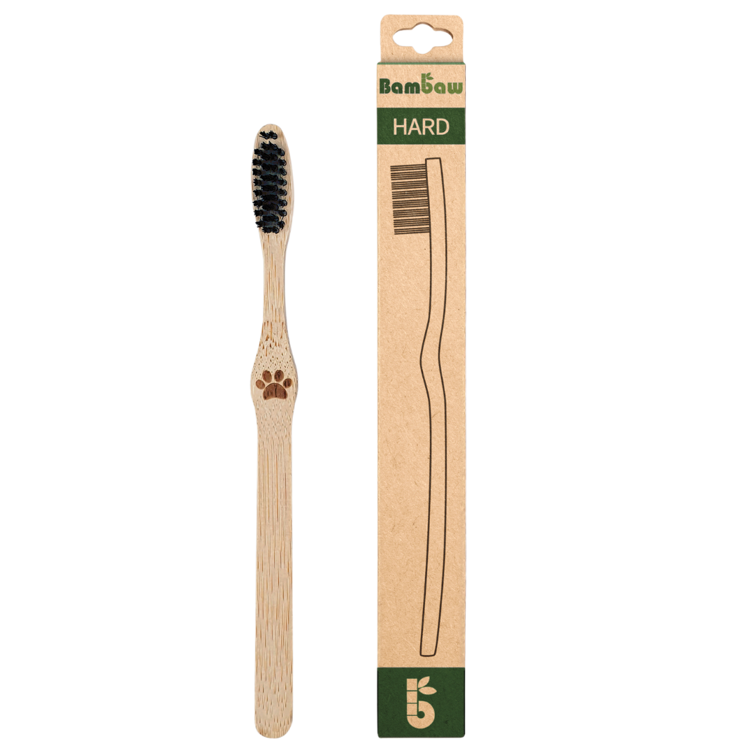 Bambaw bamboo toothbrush with black bristles beside its tall kraft packaging labeled HARD