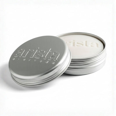 Silver shampoo bar tin with 'arista' branding on a white background