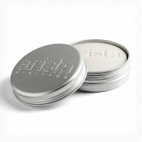 Silver shampoo bar tin with 'arista' branding on a white background