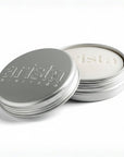 Silver shampoo bar tin with 'arista' branding on a white background