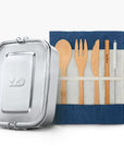 Metal lunch tin next to a teal fabric roll holding wooden cutlery for the two piece back to school bundle