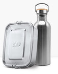 Shiny stainless steel non insulated bottle with a wooden lid and metal handle beside a metal lunch tin
