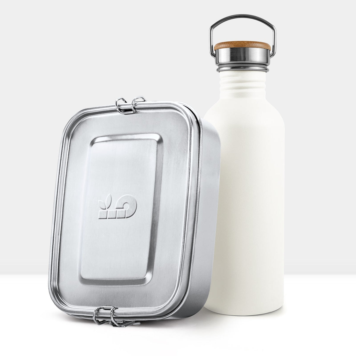 Cream white non insulated bottle with a wooden lid and metal handle beside a metal lunch tin