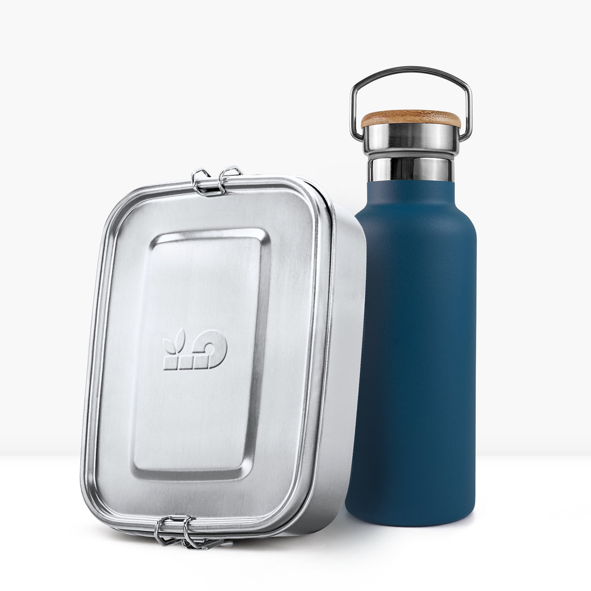 Blue insulated bottle with cork lid beside a silver metal lunch tin.