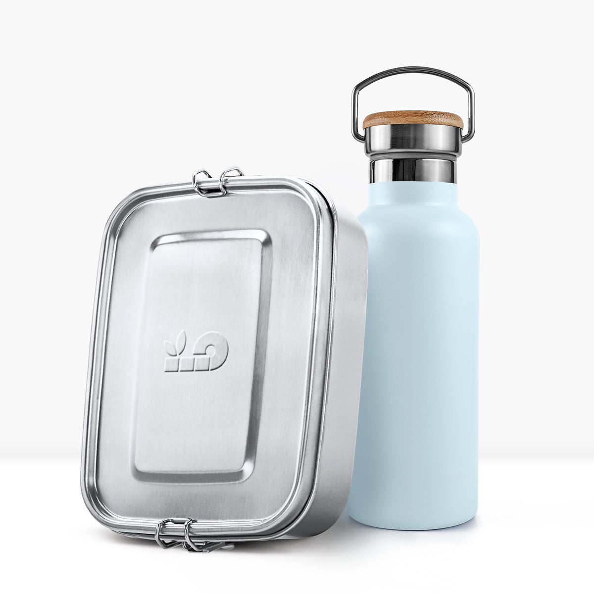 Pastel blue insulated bottle beside a silver metal lunch tin.