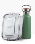 Green insulated bottle with cork cap and metal handle beside a silver lunch tin.