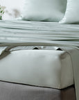 bambaw cozy bamboo bed sheets close up on a bed with fitted sheets and pillows in grey colour