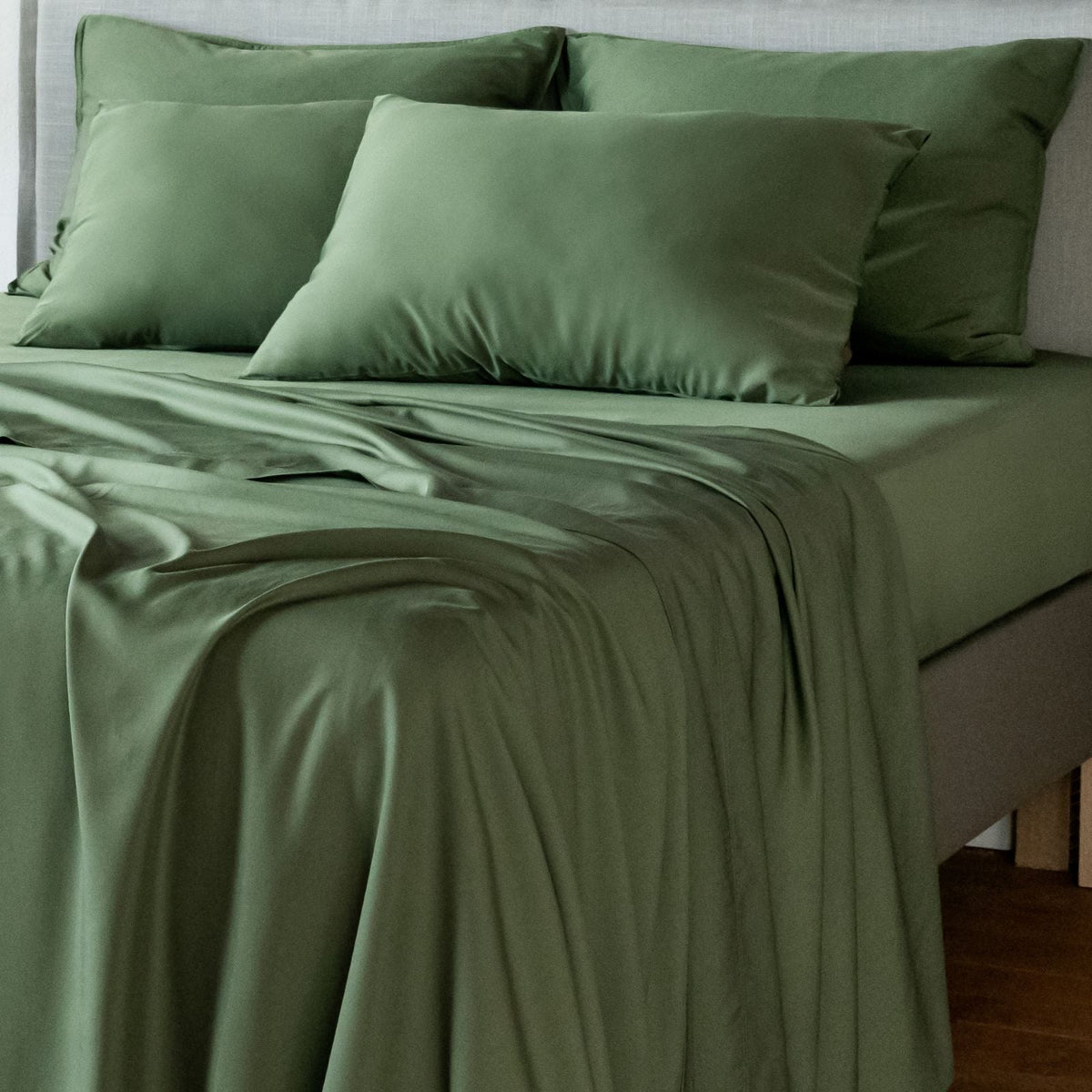 bambaw cozy bamboo bed sheets close up on a bed with flat sheets and pillows in olive green colour