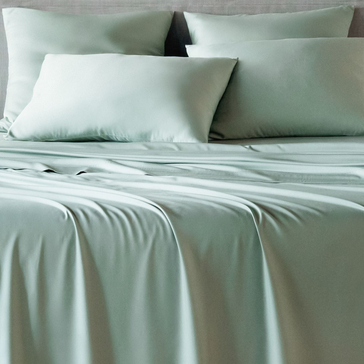 bambaw cozy bamboo bed sheets close up on a bed with flat sheets and pillows in sea glass colour