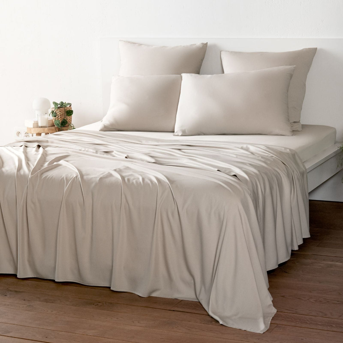 Bambaw Cozy bamboo flat sheet, fitted sheet and pillowcases in sand beige colour on a bed in a bright room