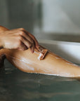 Person shaving their leg with a Bambaw saferz razor in a bathtub