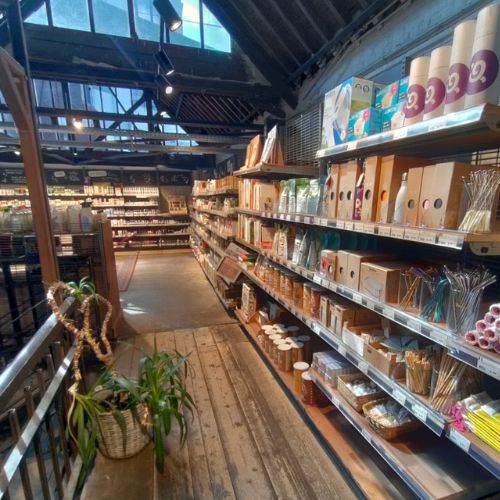 A well-lit grocery store aisle with shelves stocked with bambaw reusable products.