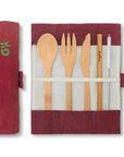 Open burgundy bamboo cutlery roll showing spoon fork knife and serrated blade arranged in slots