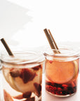 Bamboo straws placed in two jars of fruity drinks