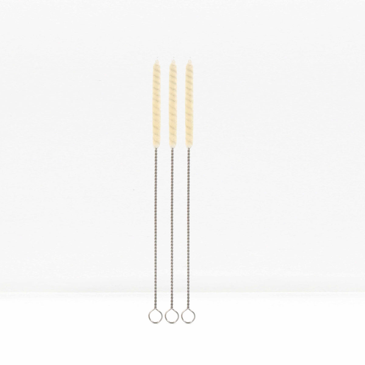 Three cotton straw cleaning brushes with twisted metal handles standing upright against a white background.