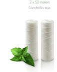 Two white floss spools with mint leaves beside Candellila wax packaging showing 2 x 50 meters